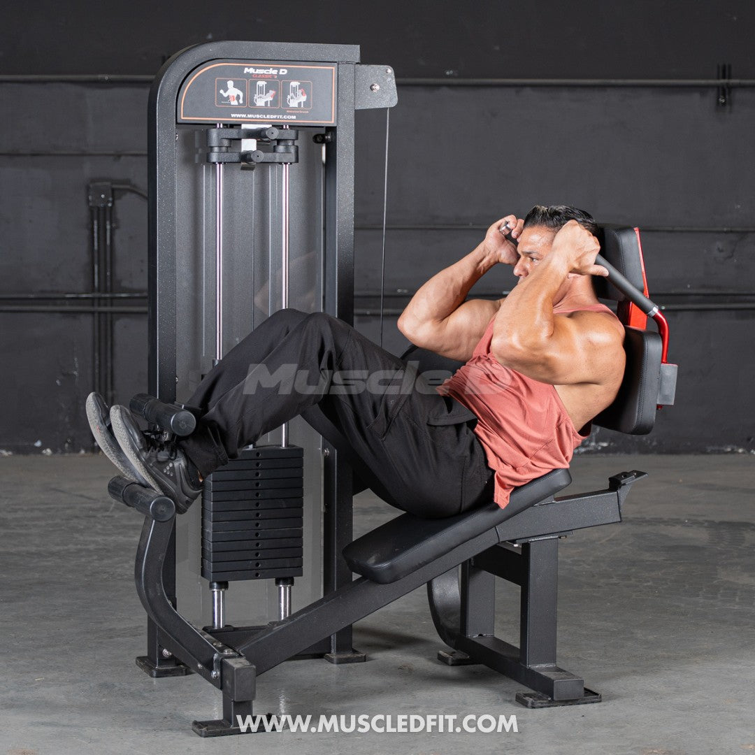 Person using a Classic V2 Abdominal Crunch machine with 'Muscle D' branding in the background