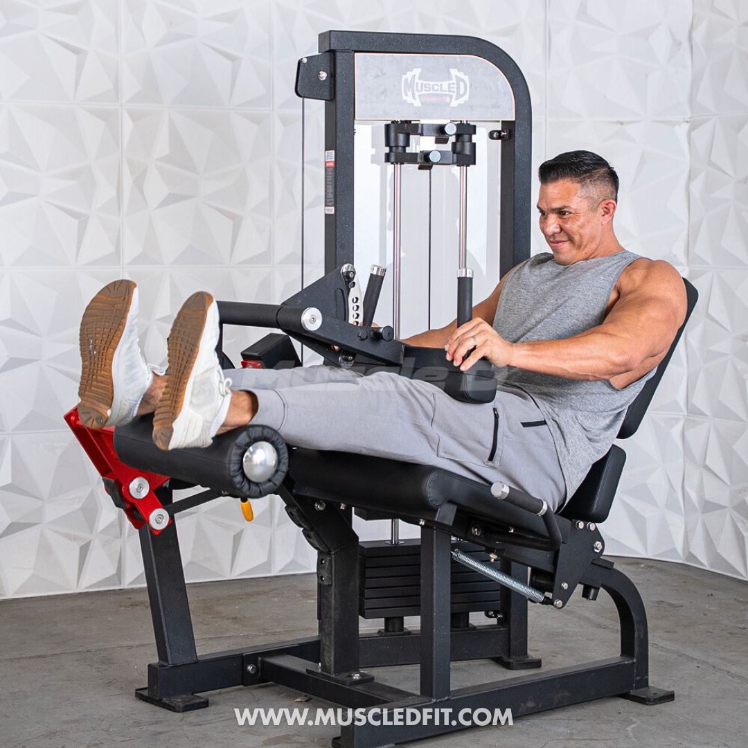Man exercising on a Classic V2 Selectorized Leg Extension / Seated Leg Curl Combo machine with a textured white wall background