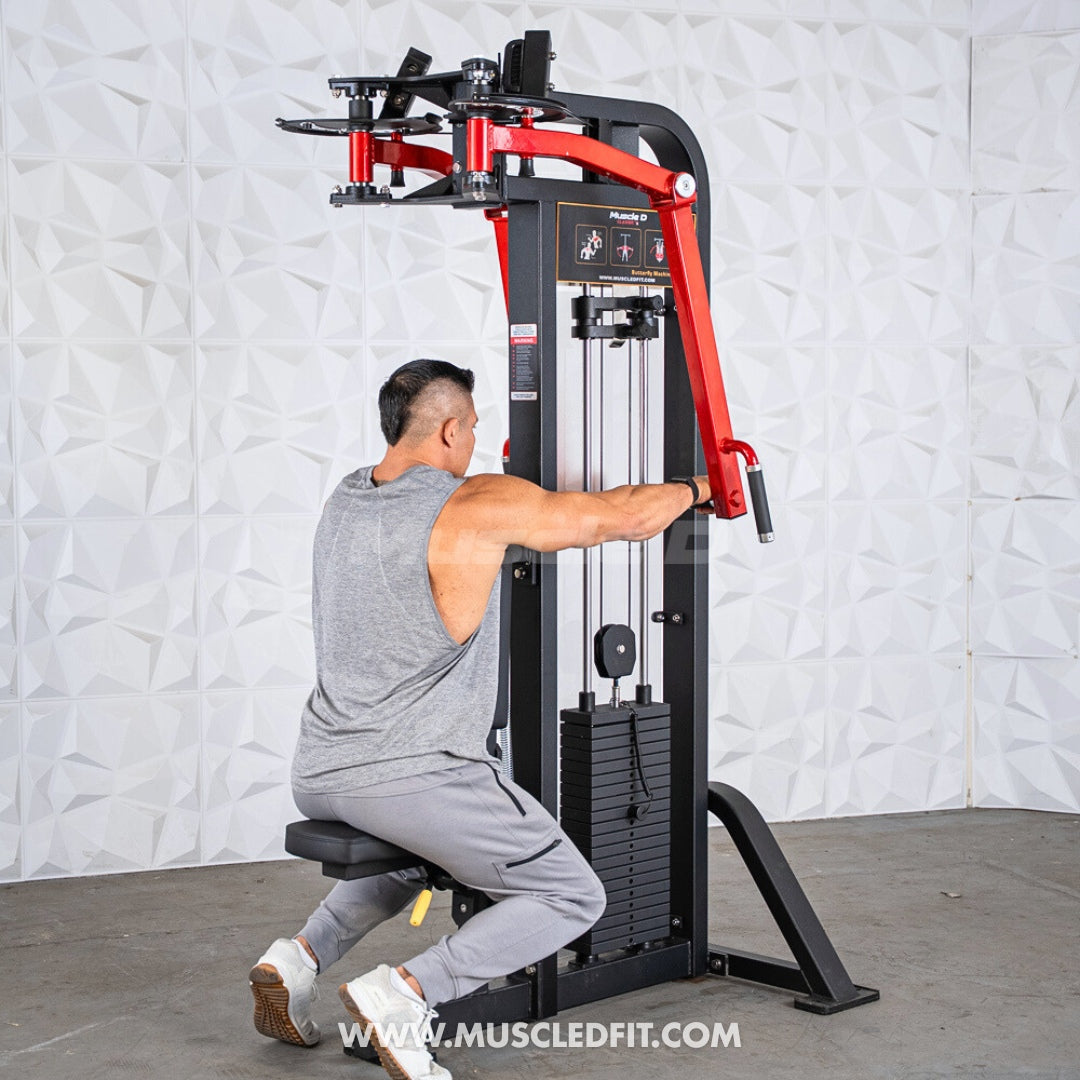 Person using a red and black Classic V2 Pec/Rear Delt Combo machine against a white textured wall.