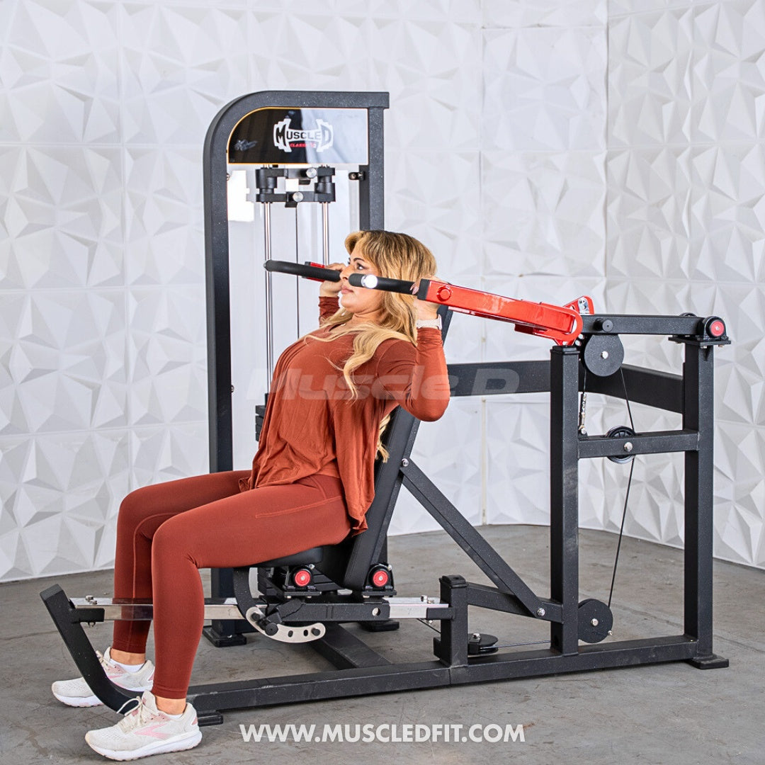 Woman using a Classic V2 Selectorized Multi-Press Chest & Shoulder Press machine in a gym setting with a textured wall background.