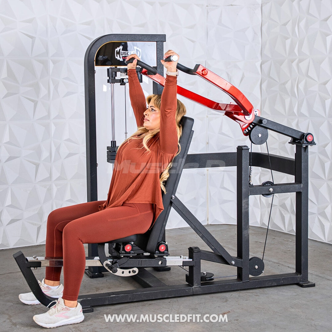 Woman exercising on a Classic V2 Selectorized Multi-Press Chest & Shoulder Press machine with a white textured wall background