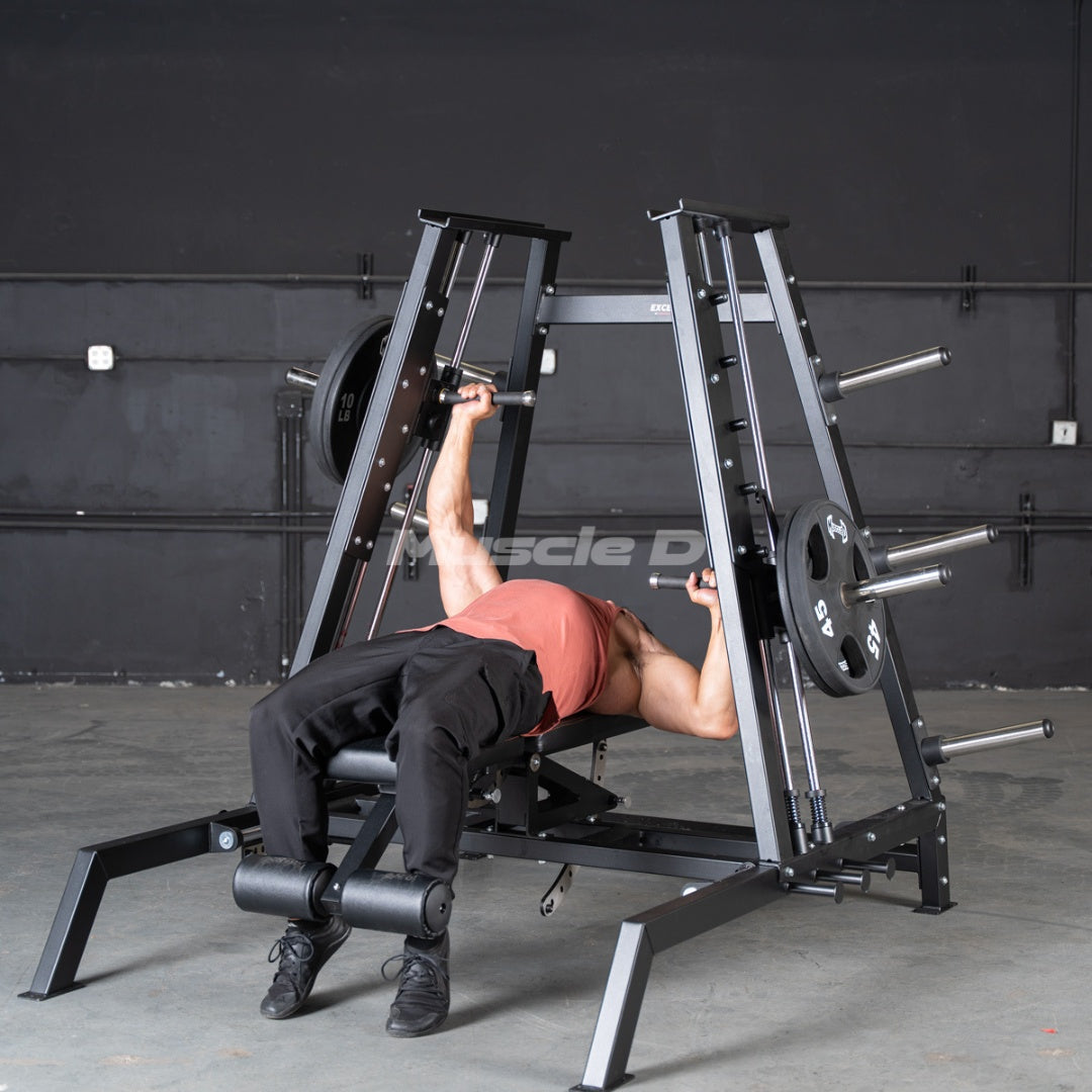 Person using an Excel Leverage Convergent Bench Press machine in a gym setting with 'Muscle D' branding.