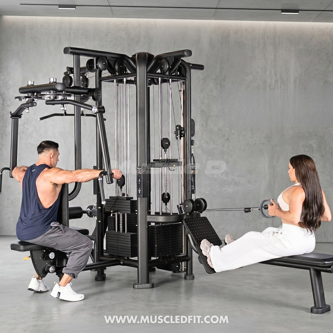 Two people exercising on a 4-Stack Jungle Gym w/ Pec / Rear Delt machine in a gym setting.
