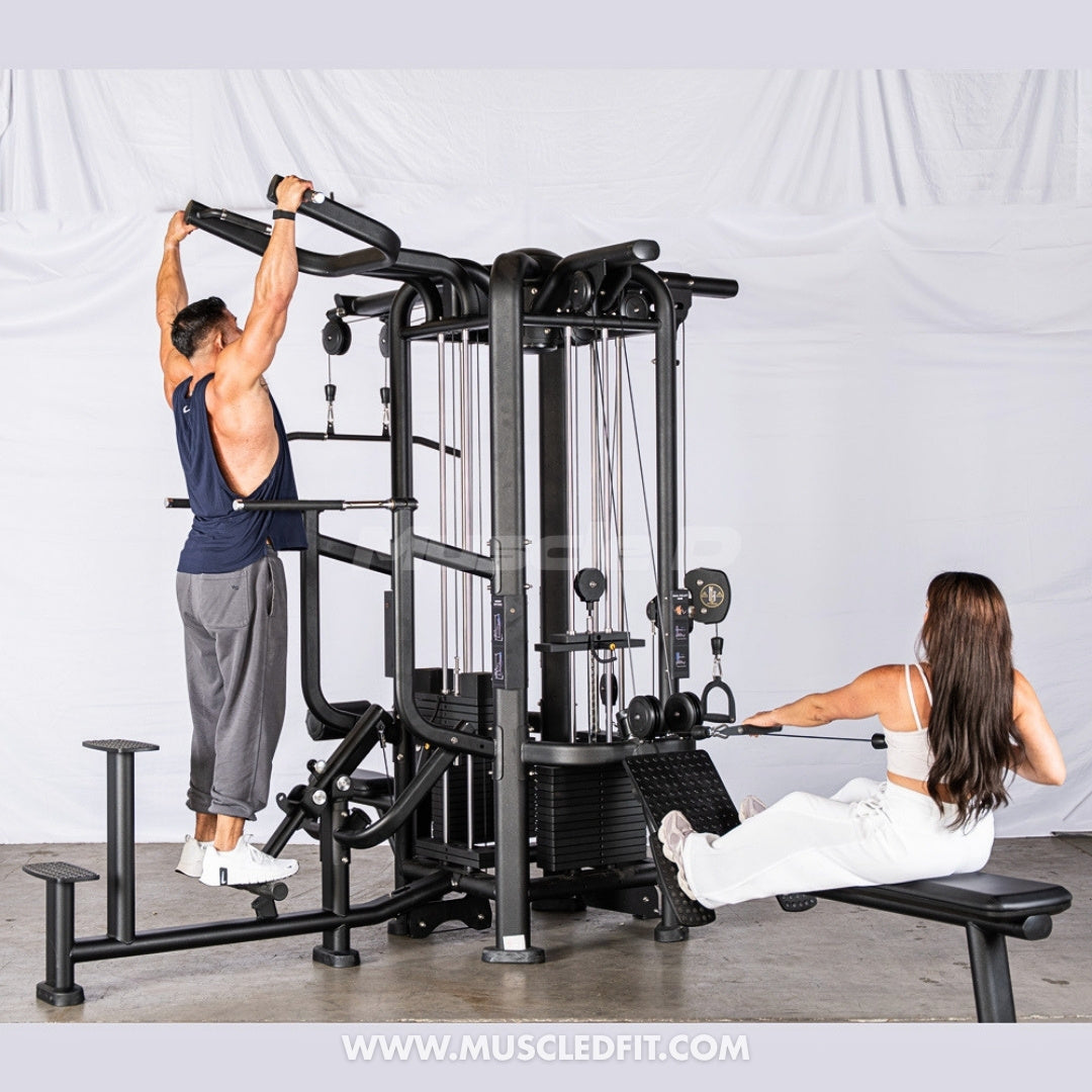 Two people using a Muscle D Functional 4-Stack machine with Assisted Chin / Dip option in a well-lit room with a white background