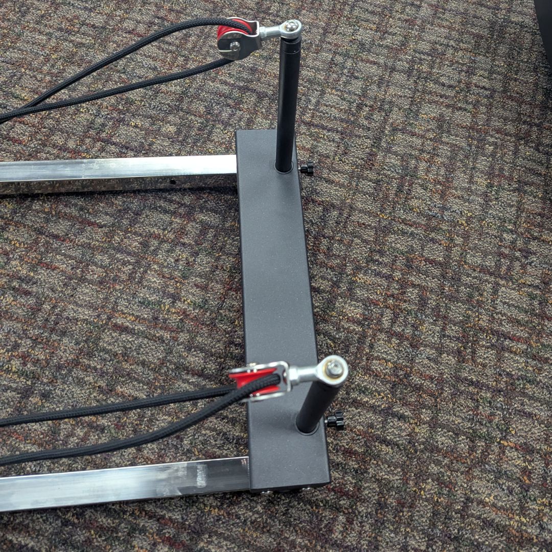 sleek light grey pilates reformer table with padded platform, adjustable foot bar, and sturdy metal frame for home or studio use