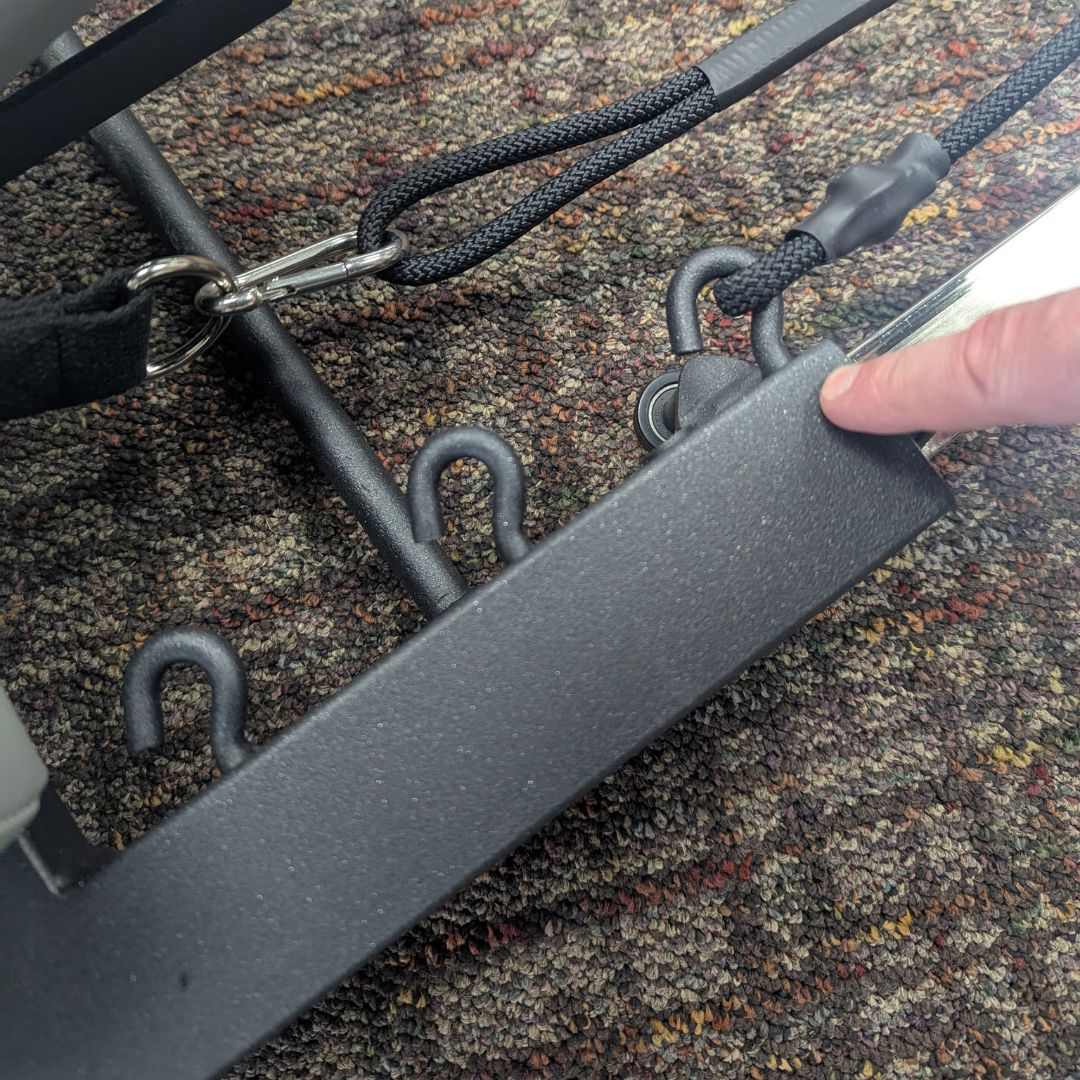 sleek light grey pilates reformer table with padded platform, adjustable foot bar, and sturdy metal frame for home or studio use