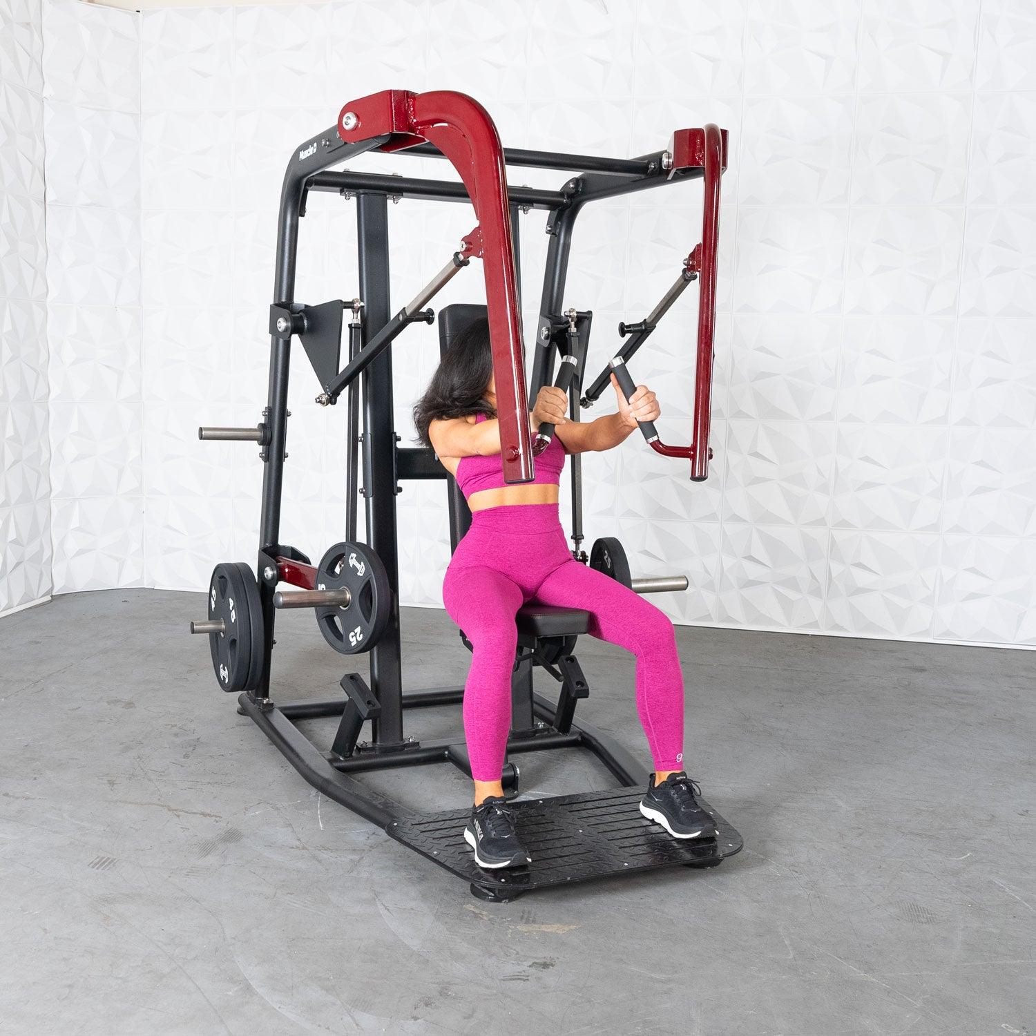 Woman usnig a Pro Strength Wide Chest Press in a gym setting by Muscle D Fitness.
