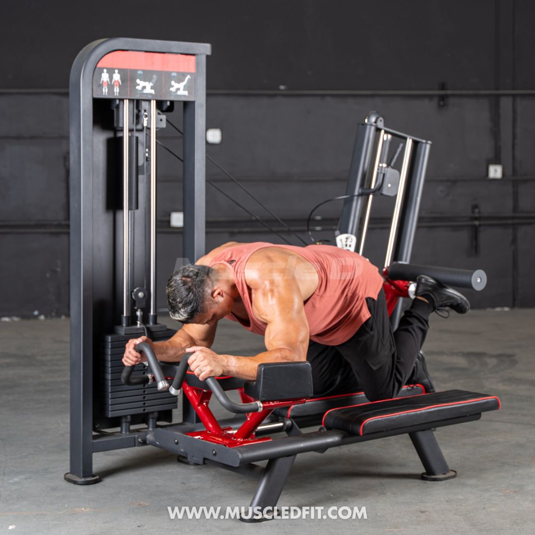 Man exercising on a Classic-V2-Glute-Kick_machine in a gym setting with 'Muscled Fit' branding.