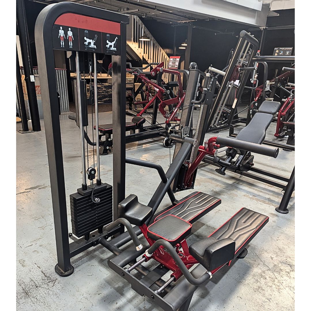 Gym equipment including a cable machine and weight bench in a gym setting.