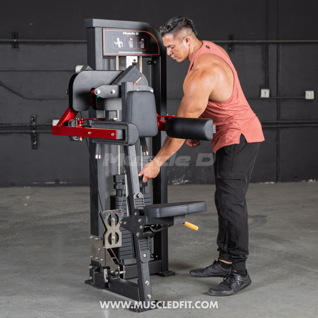 Man using a Muscle D Lateral Raise machine in a fitness setting with 'Muscle D' branding.