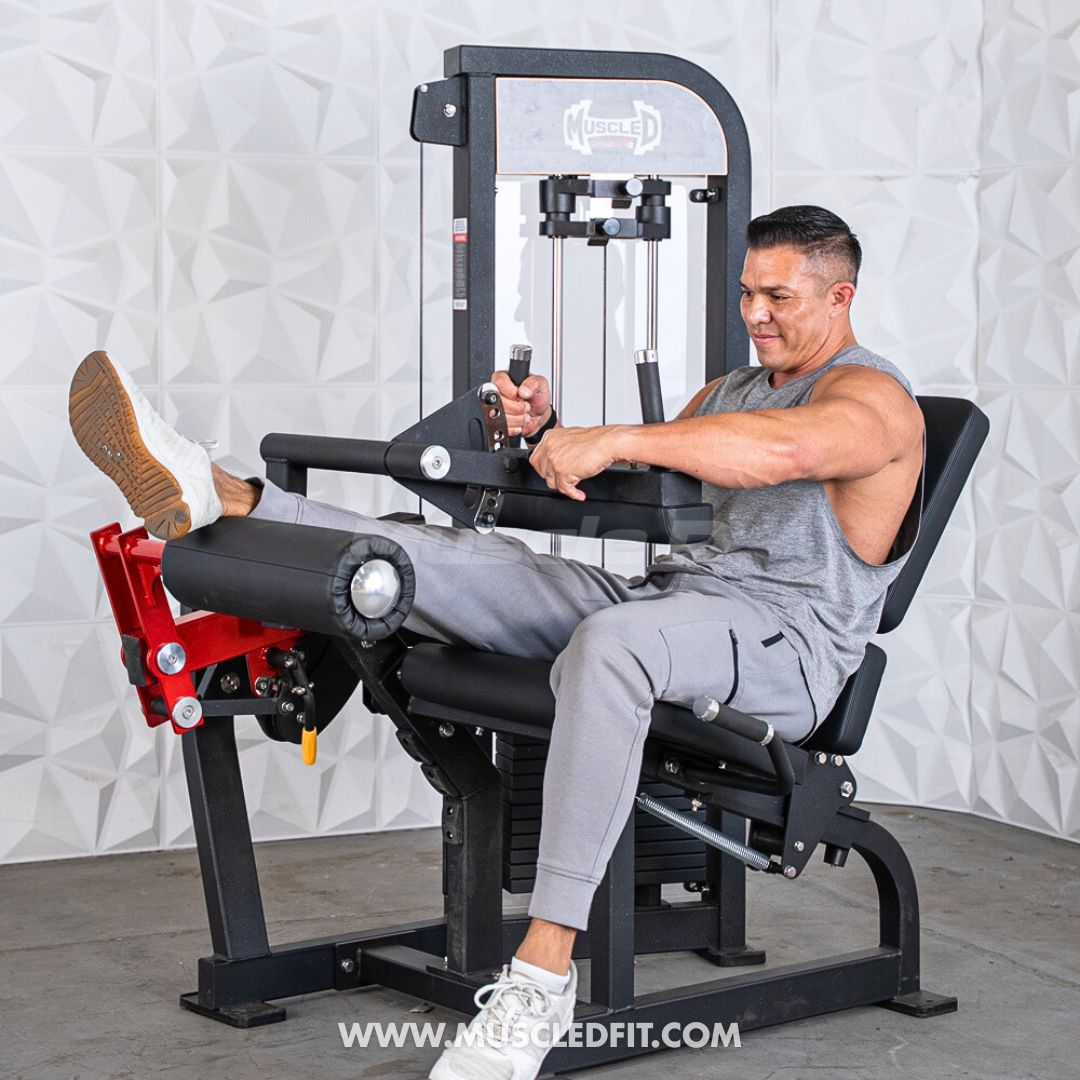 Man exercising on a Classic V2 Selectorized Leg Extension / Seated Leg Curl Combo machine in a gym setting