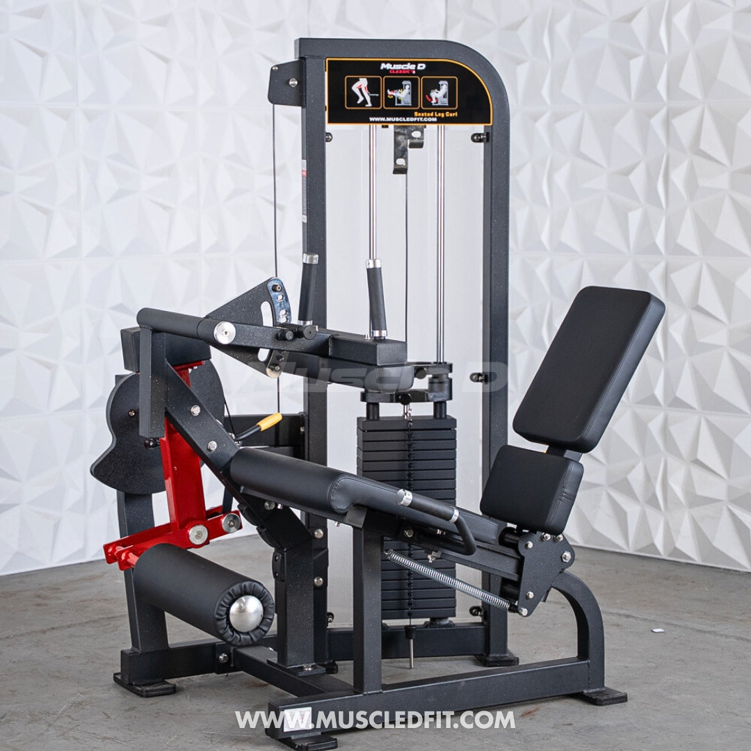 Classic V2 Seated Leg Curl with red and black design on a textured white wall background