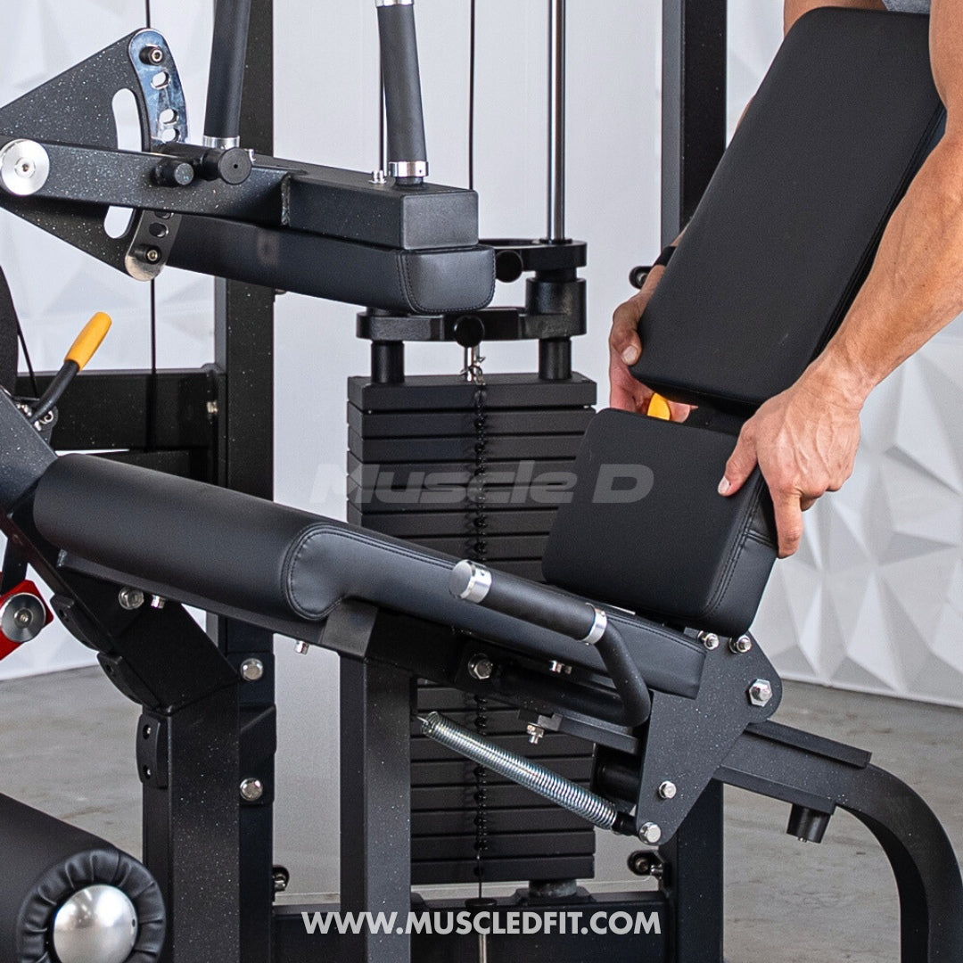 Person adjusting a Classic V2 Seated Leg Curl  in a gym setting with 'Muscle D' branding.