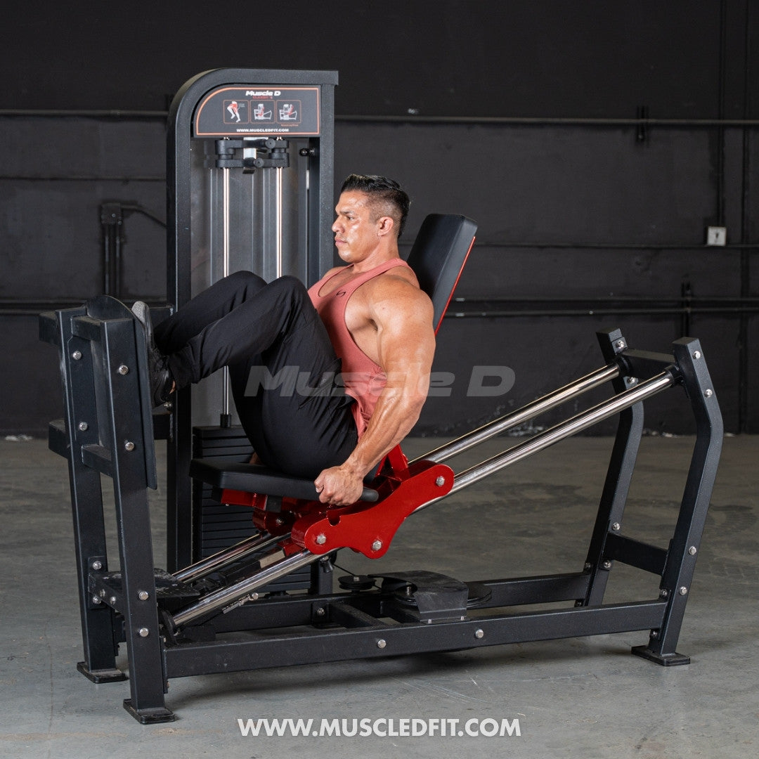 Man exercising on a leg press machine with 'Muscle D' branding in the background.