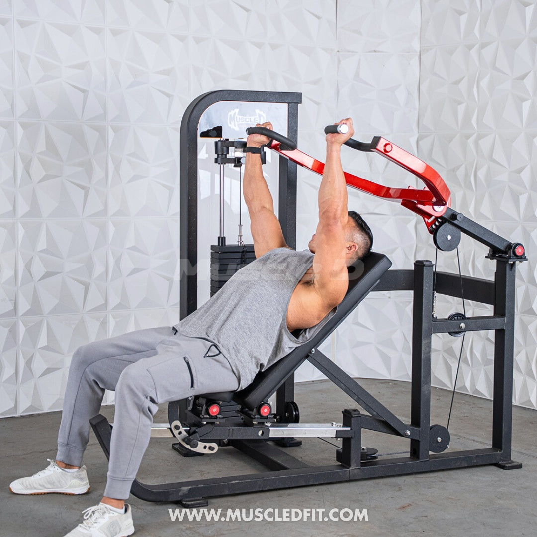 Person using a Classic V2 Selectorized Multi-Press Chest & Shoulder Press machine in a gym setting with a gray textured wall.