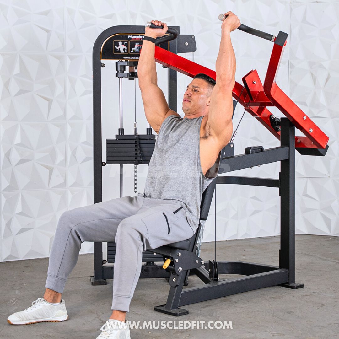 Person using a Classic V2 Shoulder Press  machine in a gym setting with a white wall background