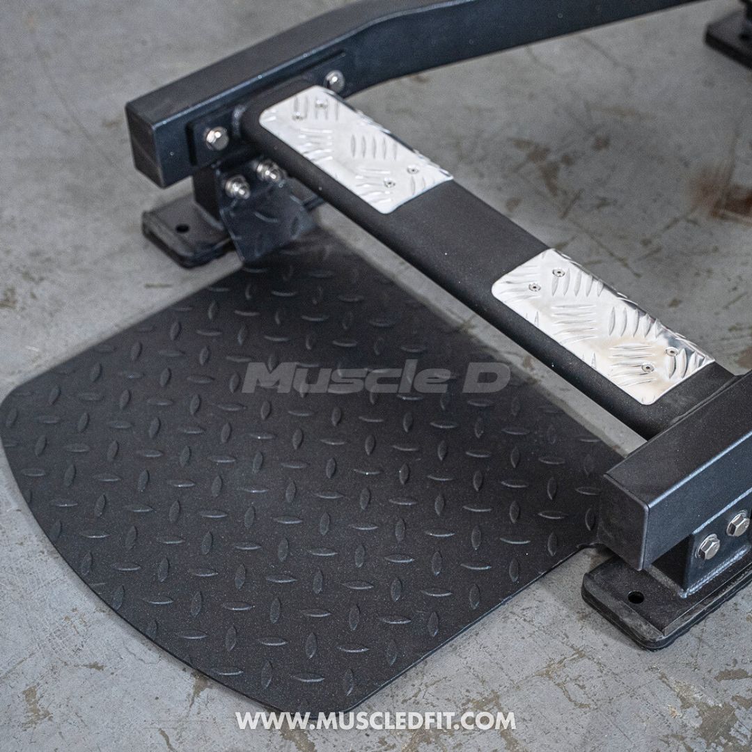 Black and silver step pad with 'Muscle D' branding on a concrete floor. 