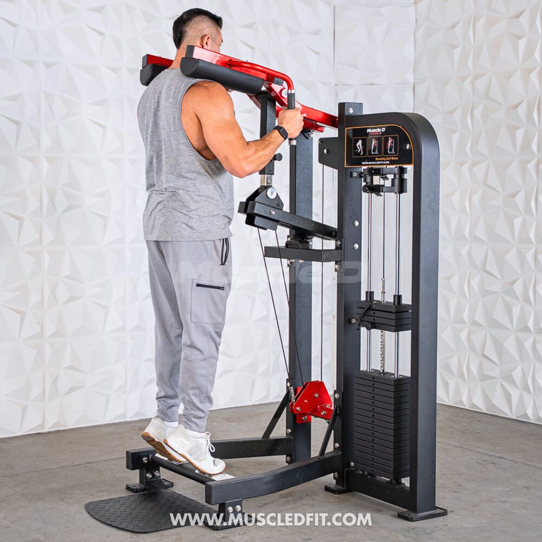 Man using a Classic V2 Selectorized Standing Calf Raise Machine in a gym setting with a textured white wall background.