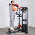 Man using a Classic V2 Selectorized Standing Calf Raise Machine in a gym setting with a textured white wall background.