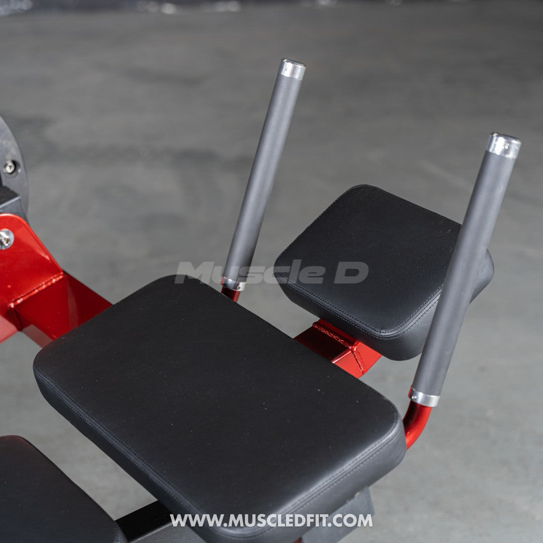 Gym machine with black padding and red frame on a gray floor, featuring 'Muscle D' branding.