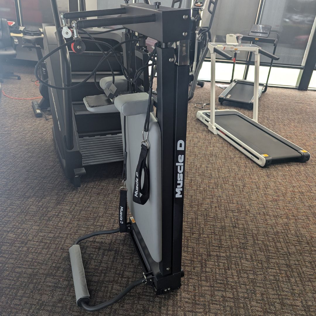 sleek light grey pilates reformer table with padded platform, adjustable foot bar, and sturdy metal frame for home or studio use