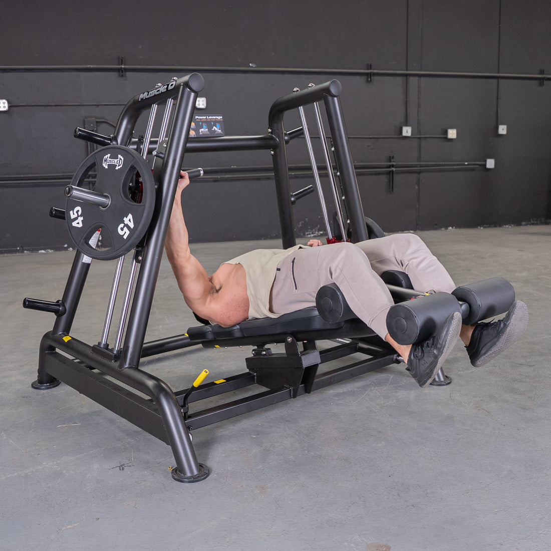 Muscle D Fitness decline chest press machine with black frame and maroon handles.