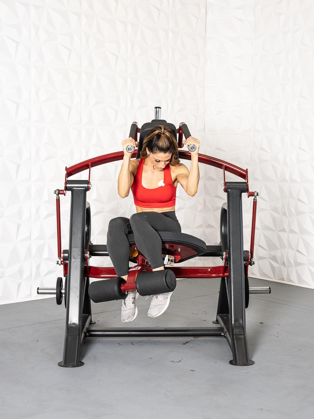 Woman using a Pro Strength Abdominal Crunch in a gym setting by Muscle D Fitness.