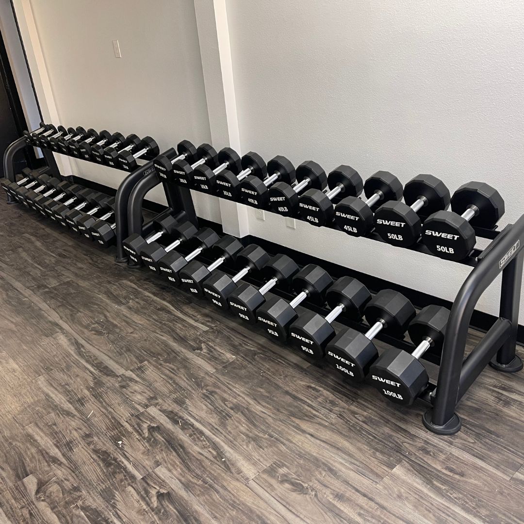 black dumbbell set five to a hundred pounds sets includes twenty pairs of dumbbells on two ten pairs dumbbell rack that is sold separately